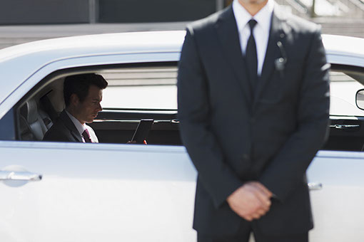 Bodyguard protecting politician in backseat of car