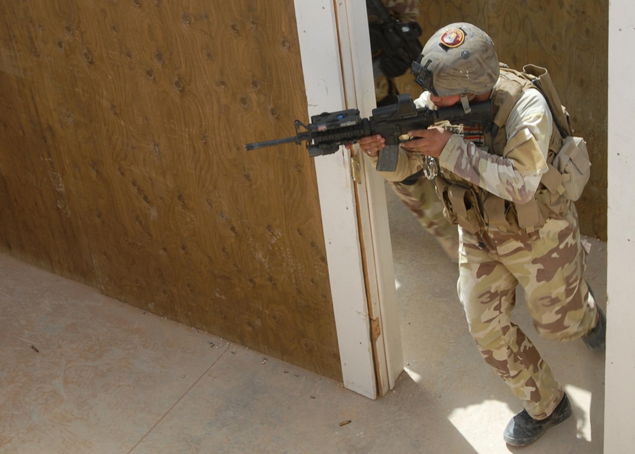 Skillfully and carefully scanning the room for threats, a 9th Regional Commando Battalion, Iraqi special operations forces, soldier begins his entry during close-quarter combat training at a military installation in Al Anbar Province, Iraq, June 10. The commandos went through the scenarios without live ammunition first, then engaged targets with live rounds as they maneuvered through the maze of obstacles and rooms.